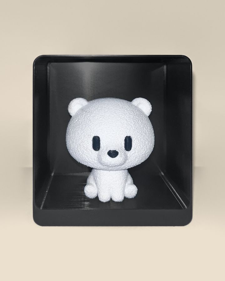 3D-printed polar bear figurine, front view: a white polar bear with black eyes and nose