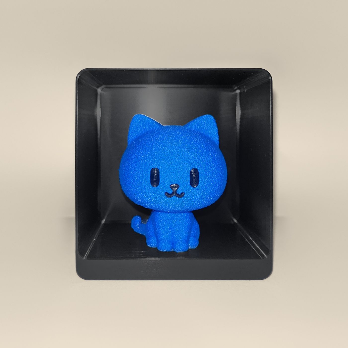 3D-printed cat figurine, front view: a blue cat with black eyes and a smiling mouth