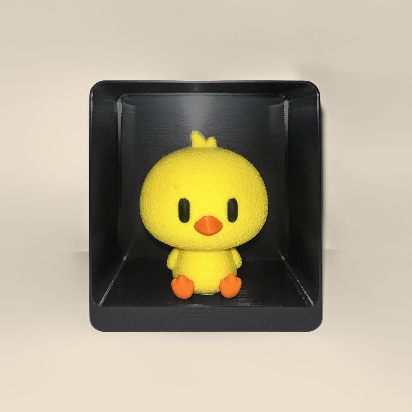 3D-printed chick figurine, front view: a yellow chick with orange beak and feet