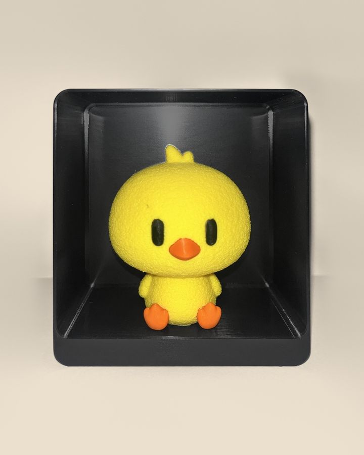 3D-printed chick figurine, front view: a yellow chick with orange beak and feet