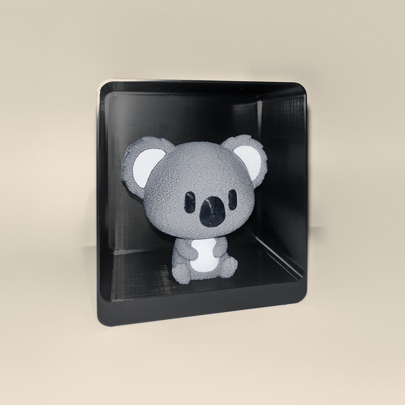 3D-printed koala figurine, angled view: a grey koala with white ears and belly and a black nose