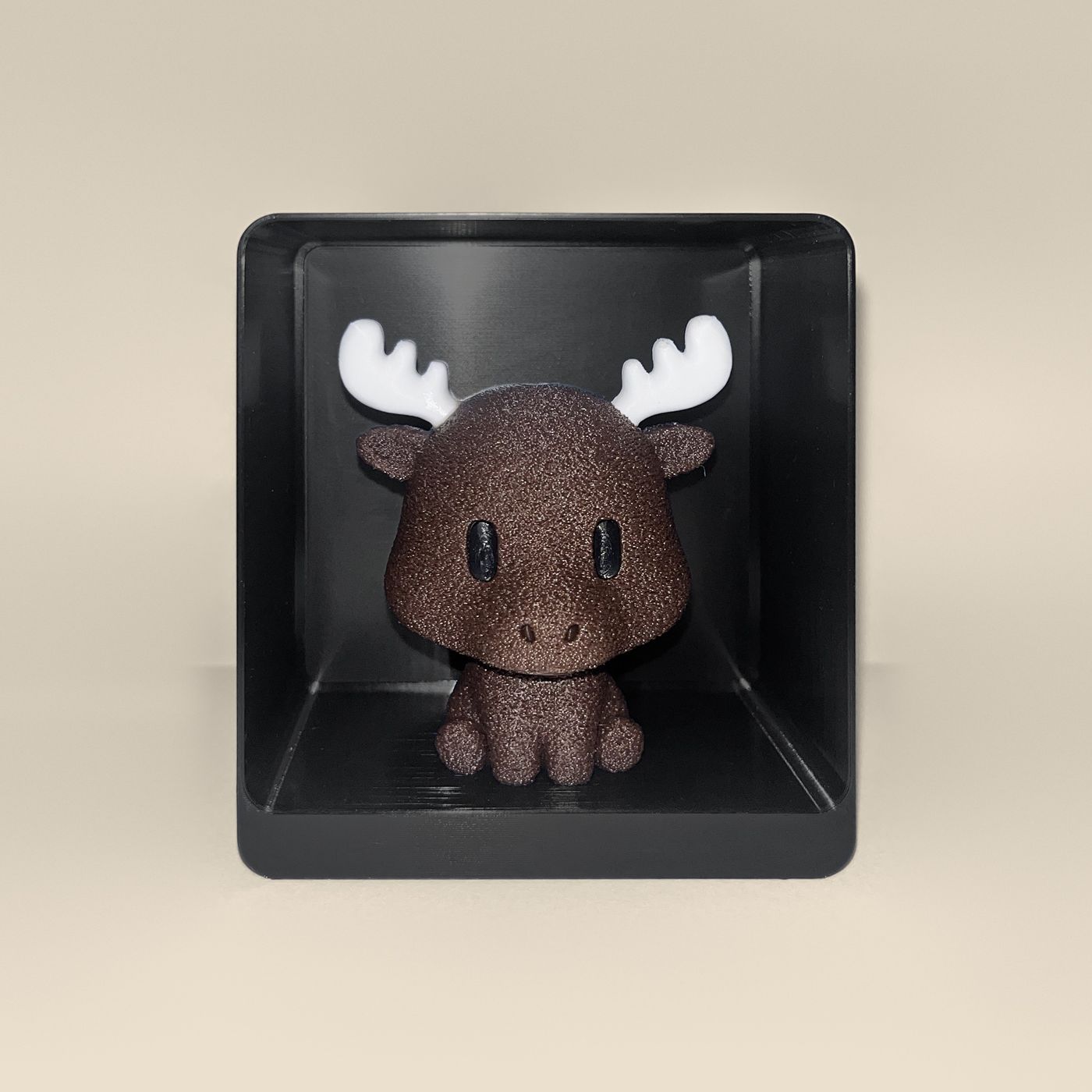 3D-printed moose figurine, front view: a brown moose with white antlers