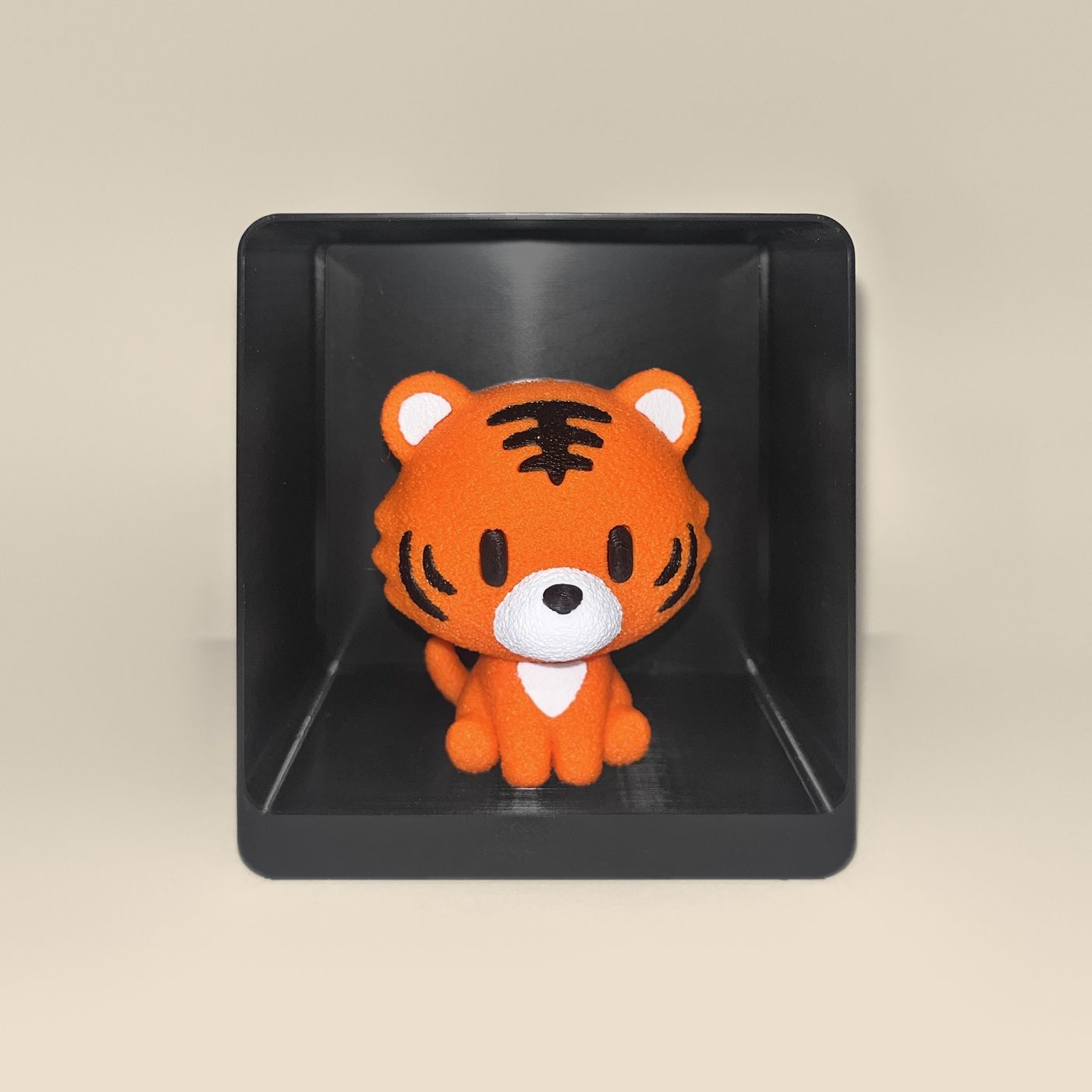 3D-printed tiger figurine, front view: an orange tiger cub with black stripes and a white muzzle